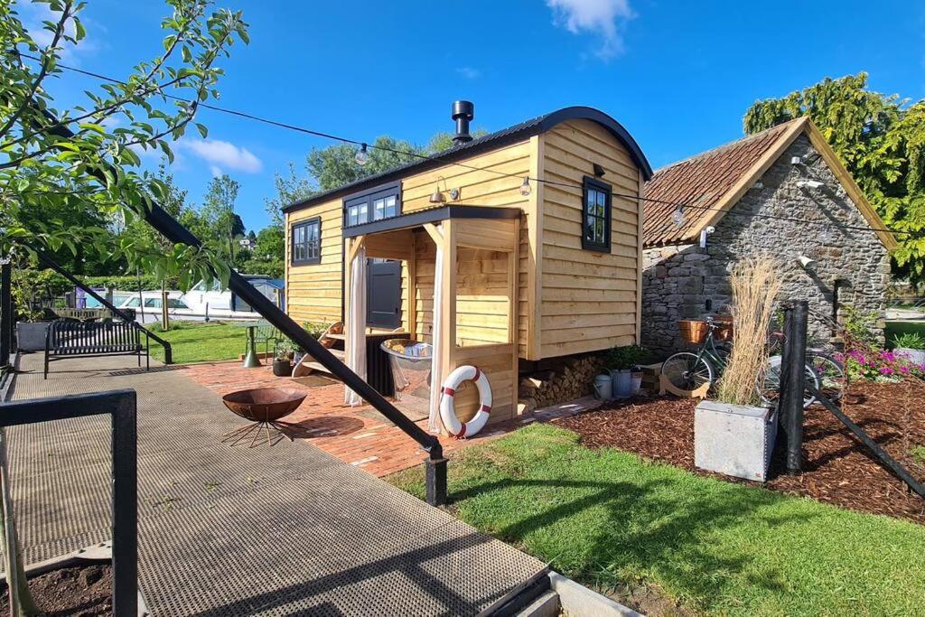Saltford的住宿－Island Hut - Outdoor bath tub, firepit and water equipment，院子里的小房子,带游乐场