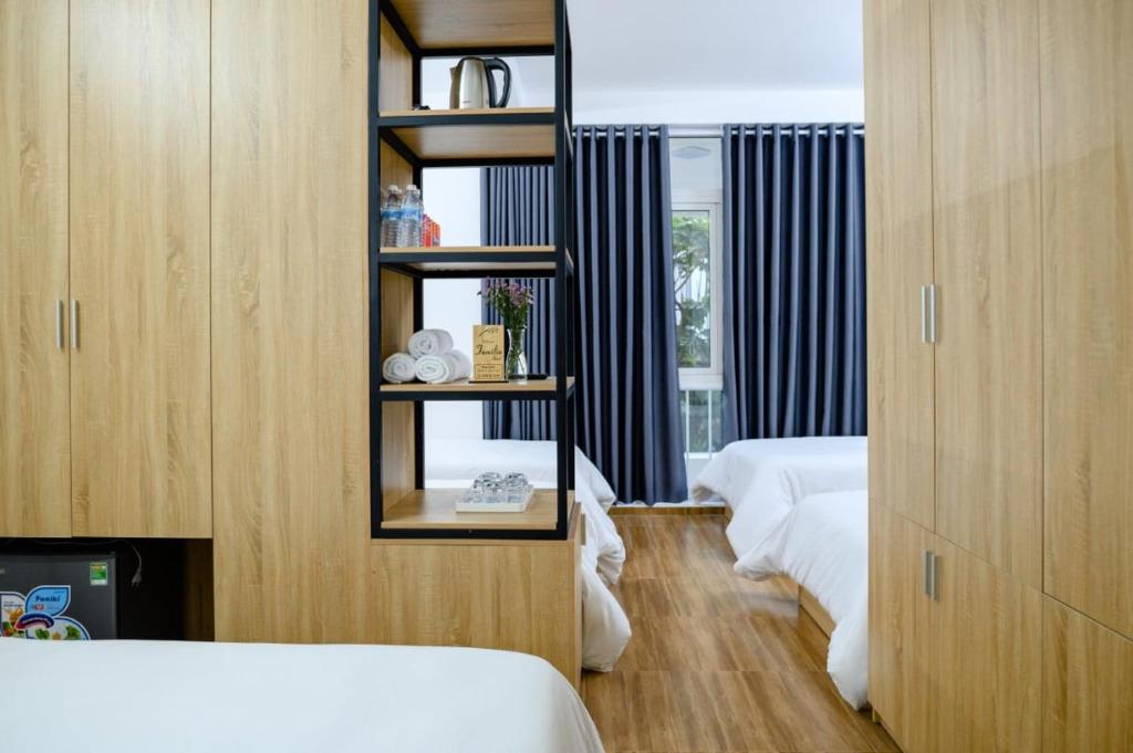 a bedroom with two beds and a mirror in a room at Familia Hotel in Hue