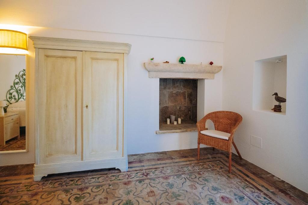 a room with a chair and a fireplace at Villa Romasi in Leuca