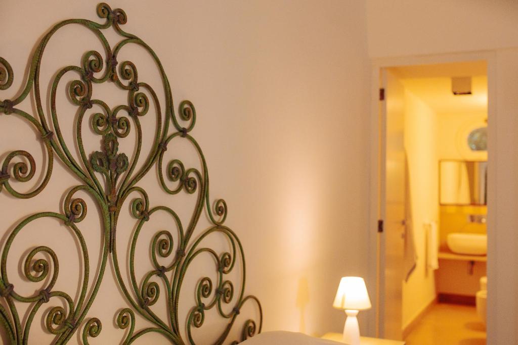 a bedroom with a bed with a metal art on the wall at Villa Romasi in Leuca