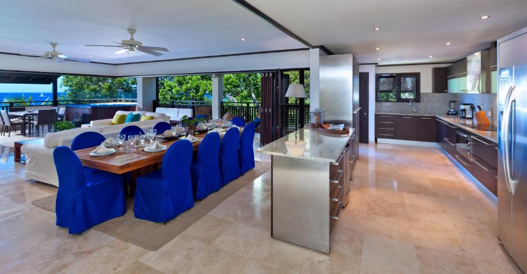 une cuisine et une salle à manger avec une table et des chaises bleues dans l'établissement Coral Cove 15, à Saint James