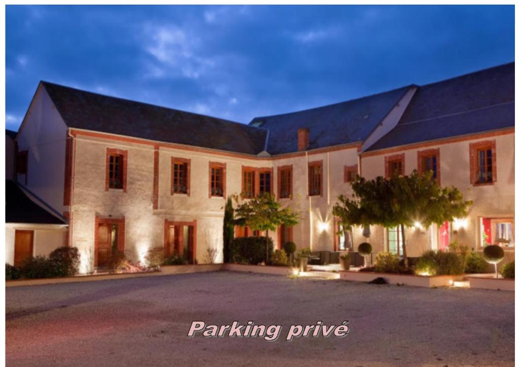 a large white building with a driveway in front of it at Hôtel Burgevin in Sully-sur-Loire