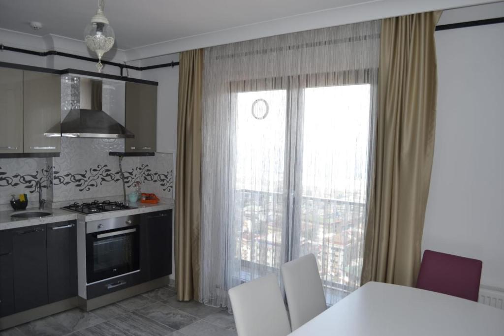 a kitchen with a window and a table with chairs at Shahin Golden Hotel l الصقر الذهبي… in Bostancı