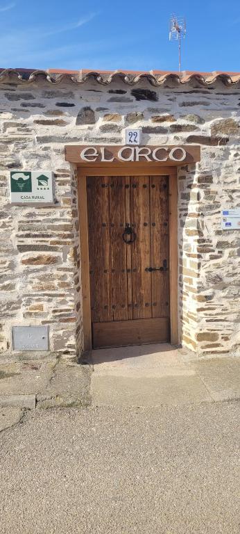 a stone building with a large wooden door at Casa Rural El Arco in La Estrella