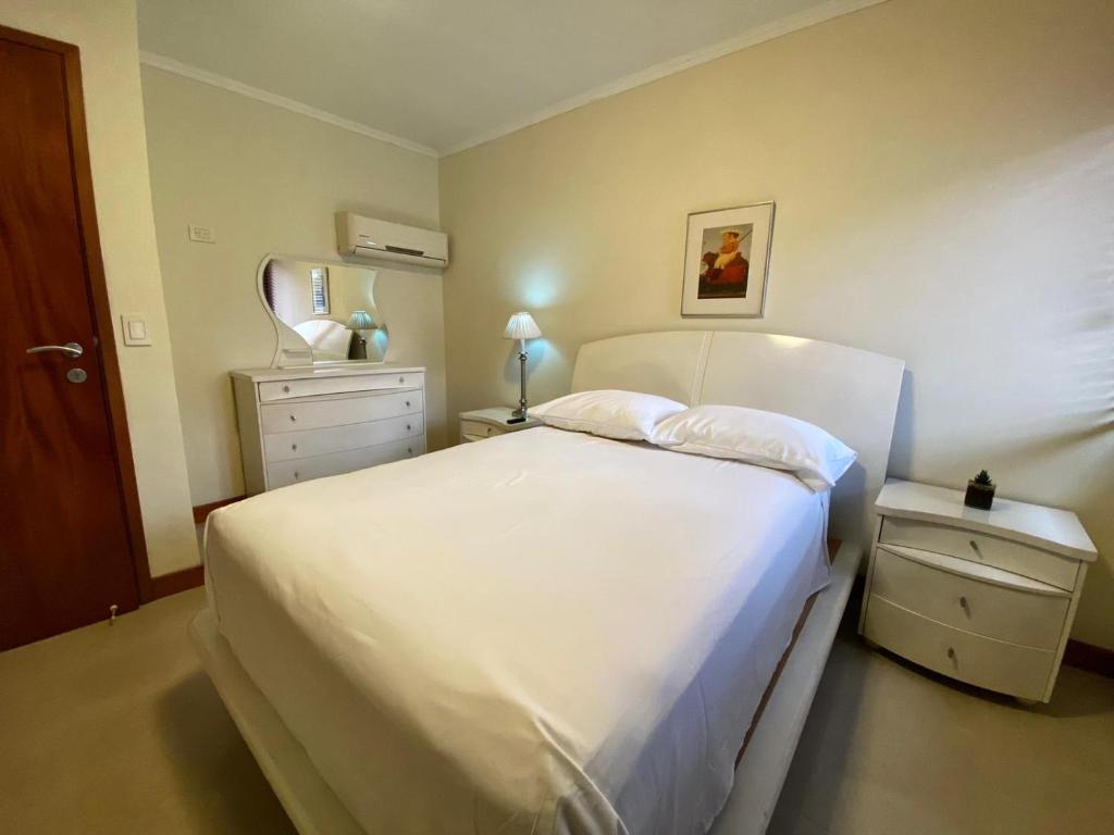 1 dormitorio con 1 cama blanca grande y espejo en Ololo Caracas, en Caracas
