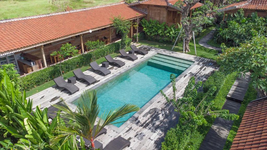una vista aérea de una piscina con tumbonas y una piscina en Bajalo Cottage Canggu en Canggu