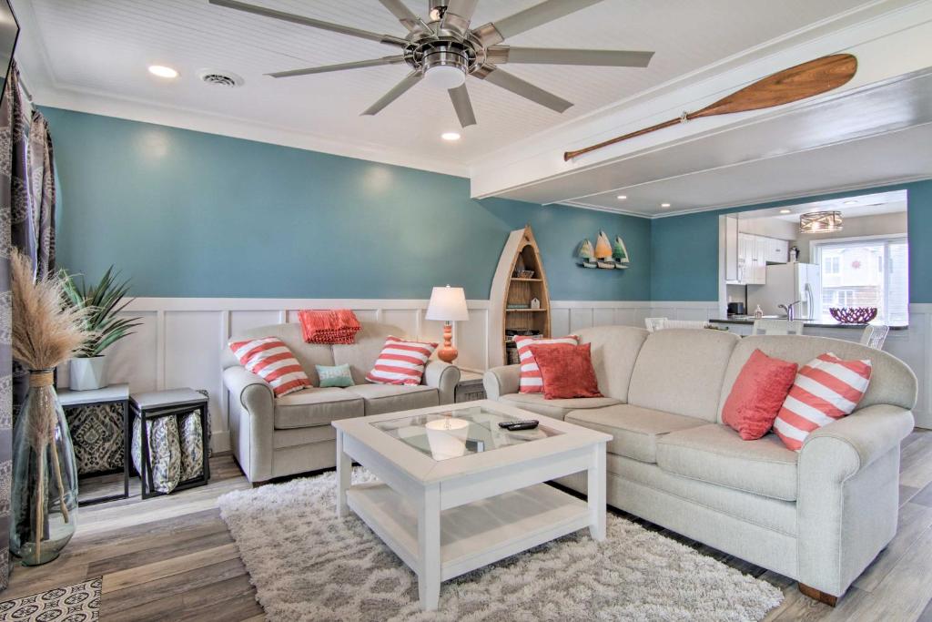a living room with two couches and a table at Walk to Maryland Beach Canal-Front Escape with Dock in Ocean City