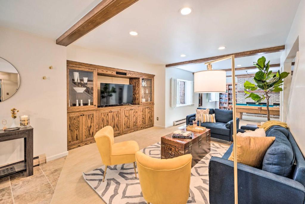 a living room with a blue couch and a tv at Luxe Garden-Level Apartment with Sauna and Gym! in Colorado Springs