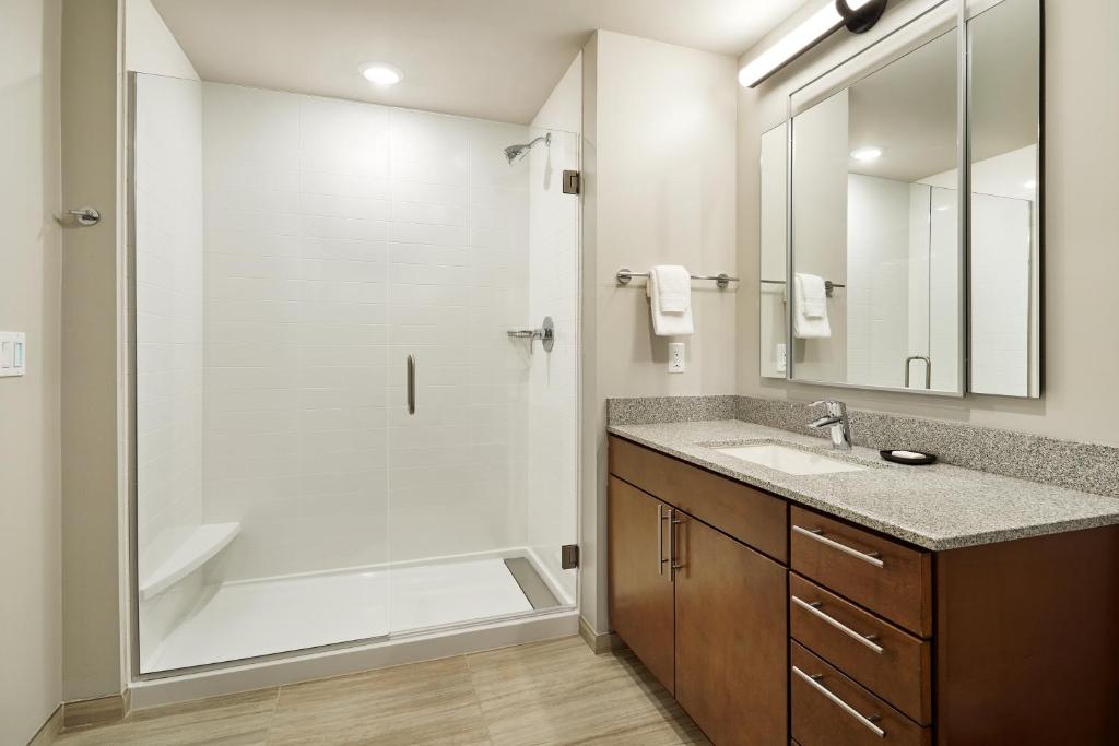 bagno con doccia, lavandino e specchio di WorldMark Moab a Moab