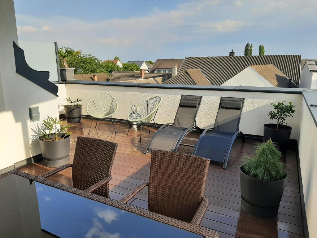 balkon z krzesłami i roślinami na dachu w obiekcie PENTHOUSE Griemann 1 mit Infrarotkabine und eigener Dachterrasse für max 4 Personen w mieście Illmitz