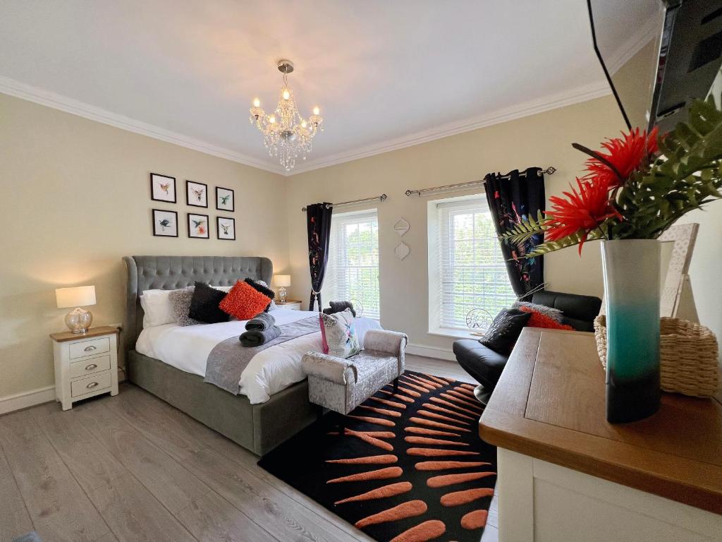 a bedroom with a bed and a chair and a table at May Bell Cottage in Dersingham
