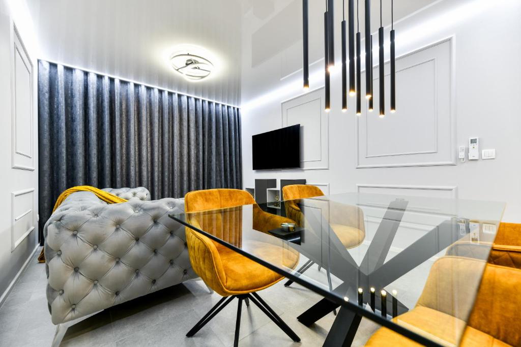 comedor con mesa de cristal y sillas amarillas en Sigma Exclusive Apartment en Zadar