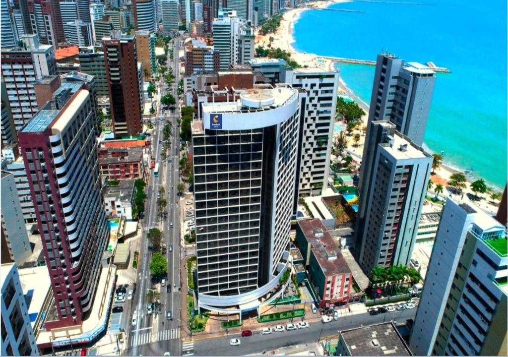 una vista aérea de una ciudad con edificios y el océano en Comfort Hotel Fortaleza en Fortaleza