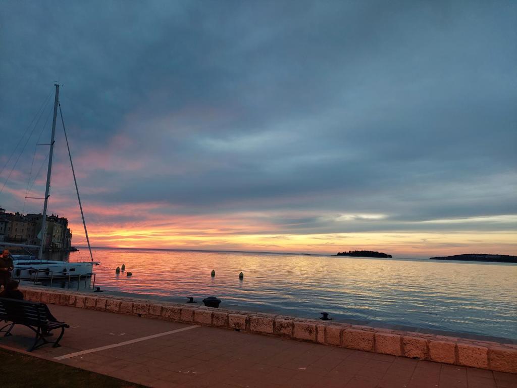 een zonsondergang boven een waterlichaam met een bank bij Campitelli view in Rovinj