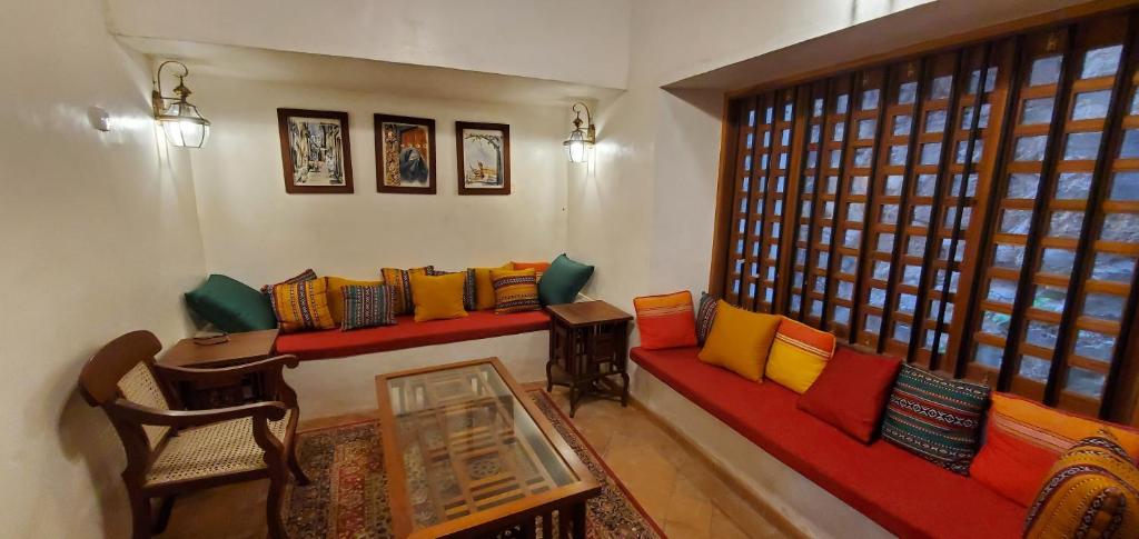 uma sala de estar com sofás coloridos e uma janela em Beytsalam em Lamu
