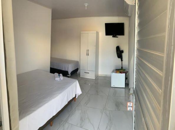 1 dormitorio con 1 cama y TV en una habitación en POUSADA FÊNIX, en Viçosa