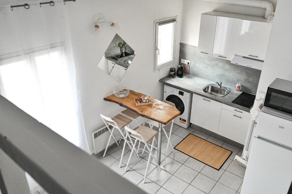 een kleine keuken met een tafel en een wastafel bij Jolie appartement climatisé in La Ciotat