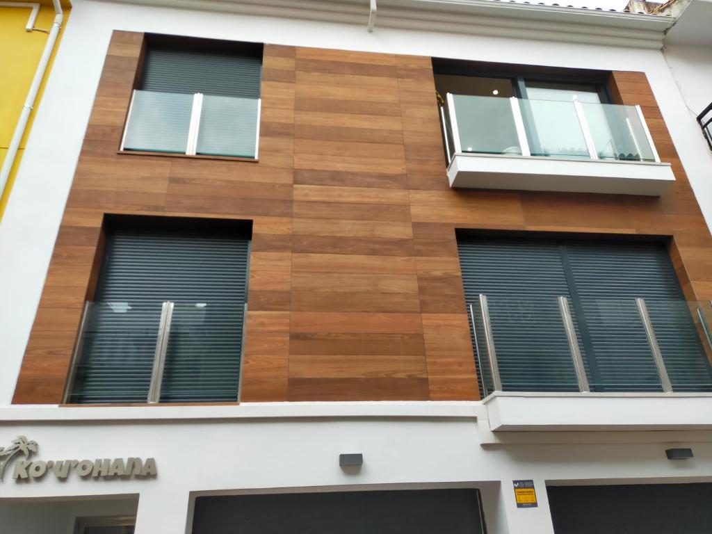 a building with wood panels on the side of it at Apartamentos Kouohana in Fuengirola