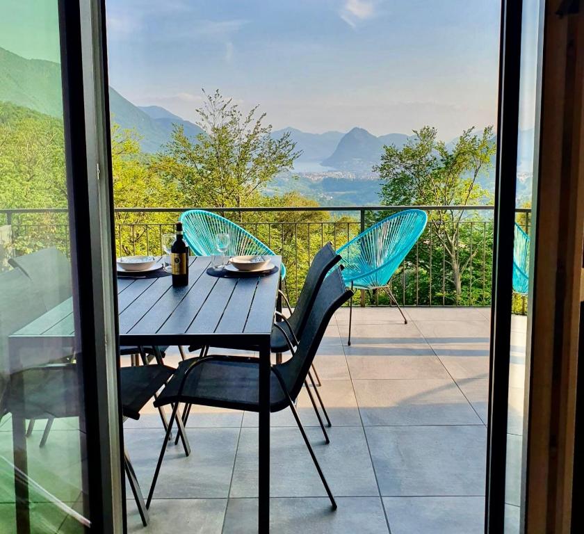 a table and chairs on a balcony with a view at Casa Cristina in Roveredo Capriasca