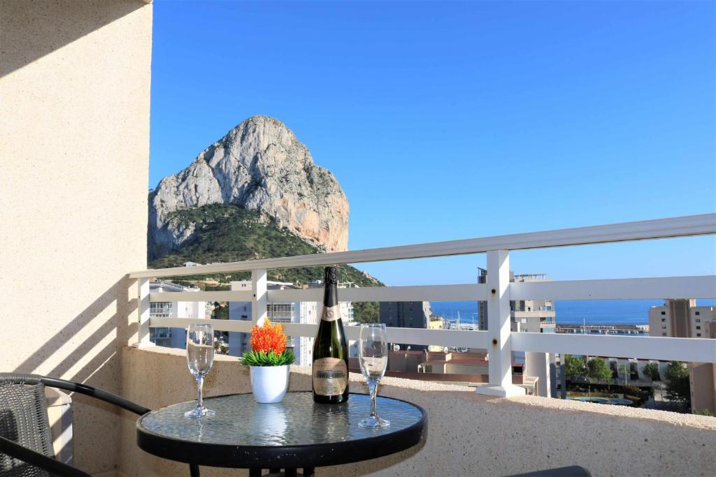 a table with wine bottles and glasses on a balcony at Apolo17 E39 2 dormitorios in Calpe