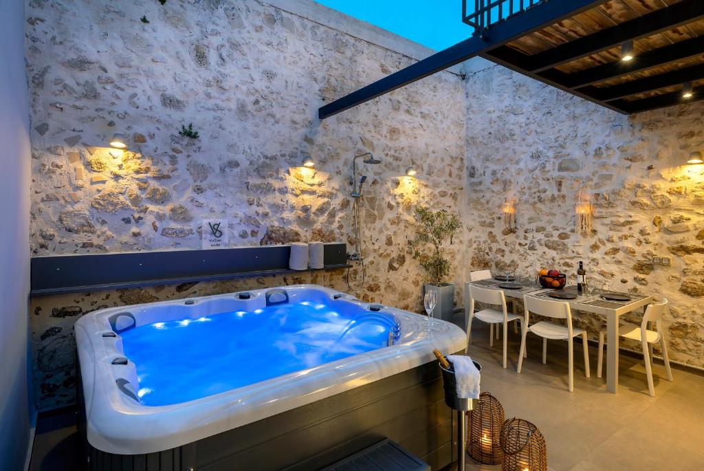 a bath tub in a room with a table at VaSan suite in Rethymno