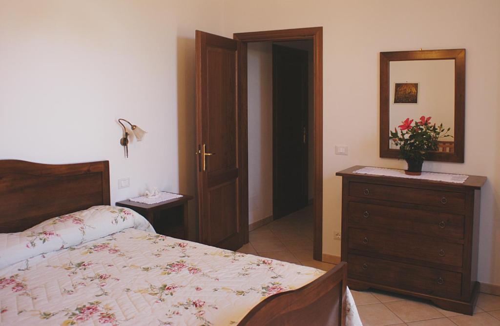 a bedroom with a bed and a dresser and a mirror at Poggio Bella Vista in Castiglione del Lago