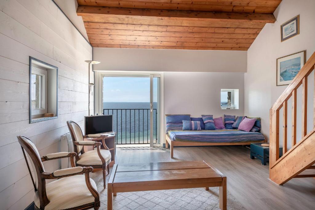 Una sala de estar con un sofá y un televisor. en Superbe vue Mer - Vacances à 5 personnes à Arzon, en Arzon