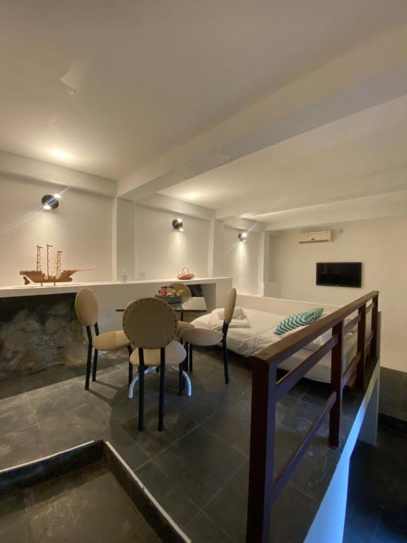 Habitación con cama, mesa y sillas. en Loft Praia dos Anjos, en Arraial do Cabo