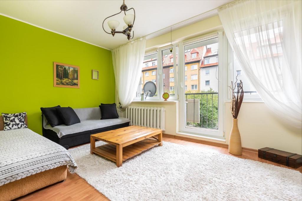 a living room with a couch and a window at Apartament - 3min od plaży - Chillout vibes in Gdańsk