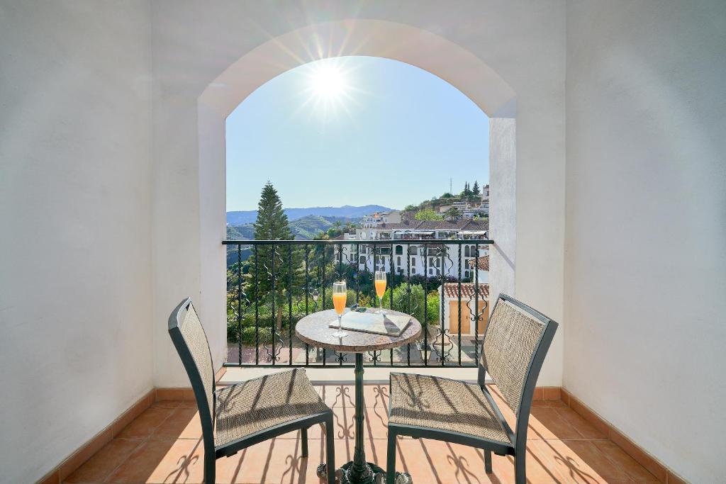 a balcony with a table and chairs and a window at Hotel Villa Frigiliana in Frigiliana