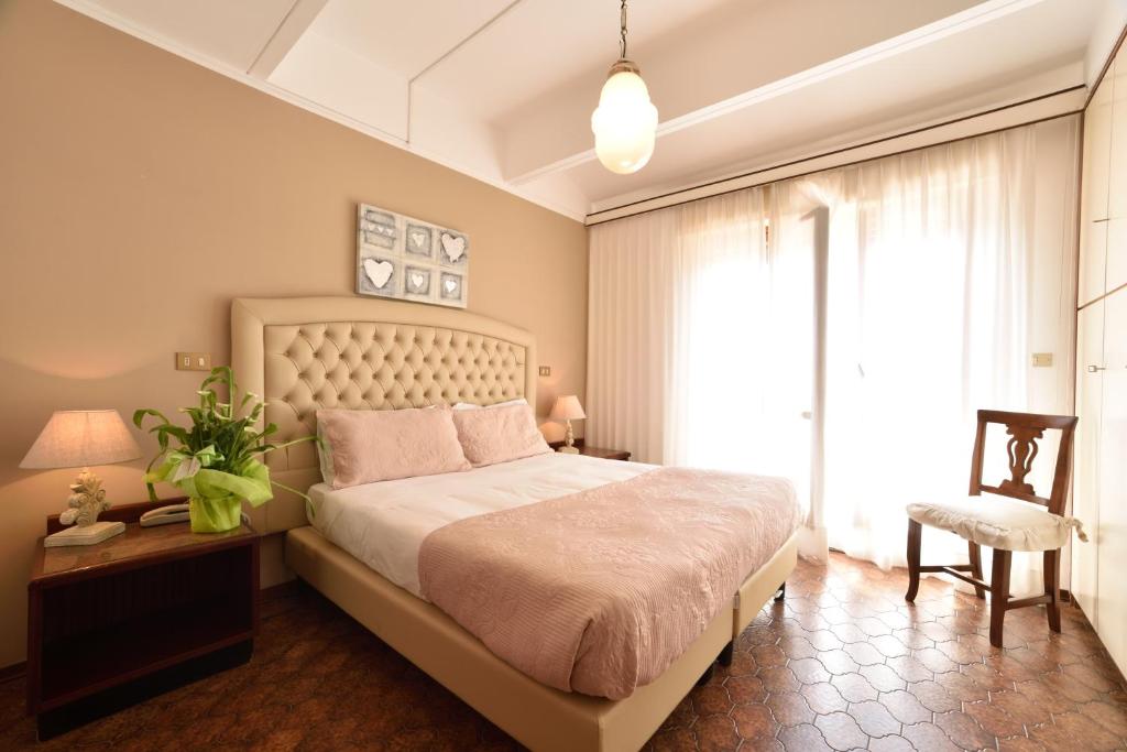 ein Schlafzimmer mit einem großen Bett und einem Stuhl in der Unterkunft Hotel Bergamo Mare Mhotelsgroup in San Bartolomeo al Mare