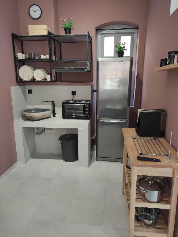 Il comprend une cuisine équipée d'un réfrigérateur et d'un comptoir avec une table. dans l'établissement Filema, à Prévéza