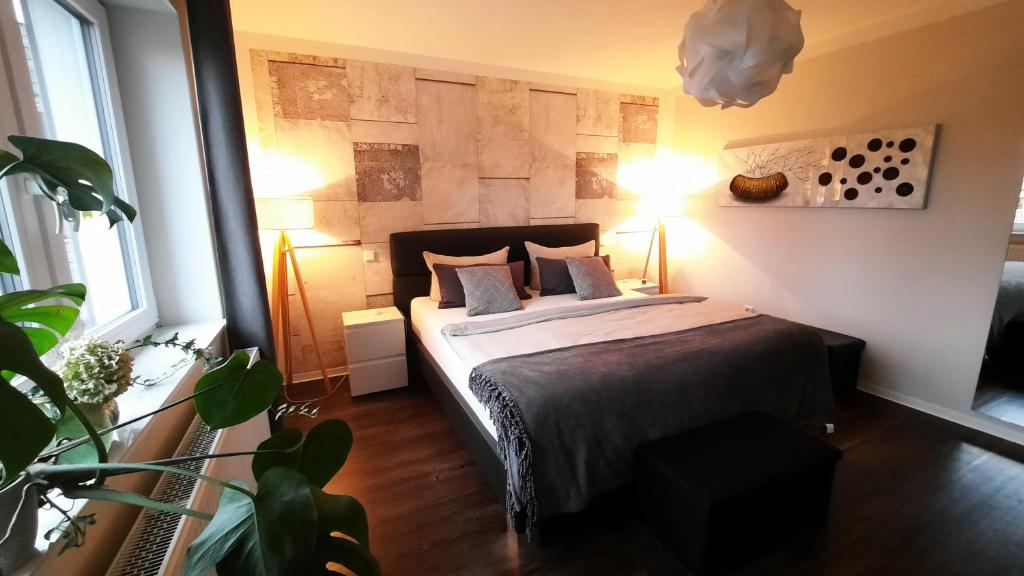 um quarto com uma cama com dois candeeiros e uma planta em Appartment Fasanenhof Klinikum und Uni nah mit Netflix em Kassel