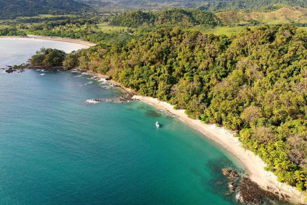 an aerial view of a beach with a boat in the water at Los Vivos Beachfront Experience in Pochote
