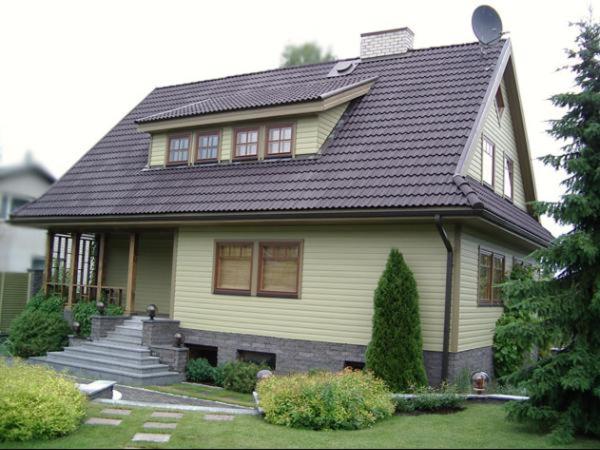 a yellow house with a black roof at Tammehouse in Otepää