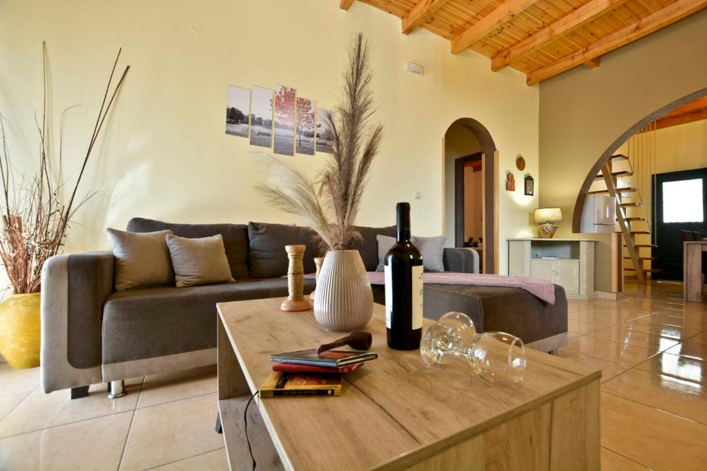 a living room with a couch and a table with wine glasses at Sia's Holiday Home in Ágios Matthaíos