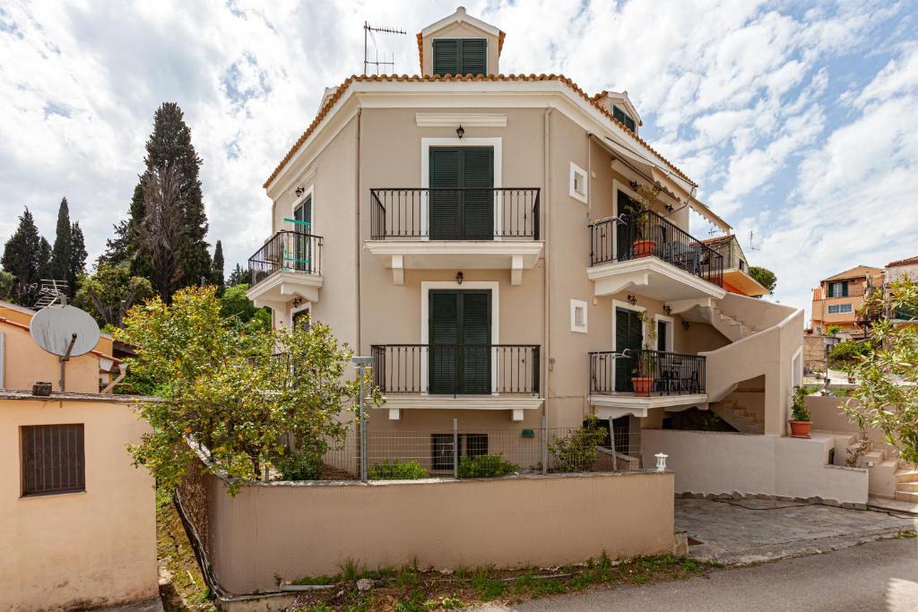 a large white house with balconies and trees at Corfu Don Camillo Apartment in (( Agía Eleoúsa ))