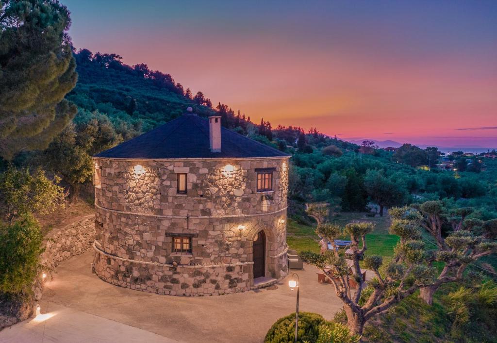 an aerial view of a stone building with a sunset in the background at Gerakomylos Stone House in Vasilikos