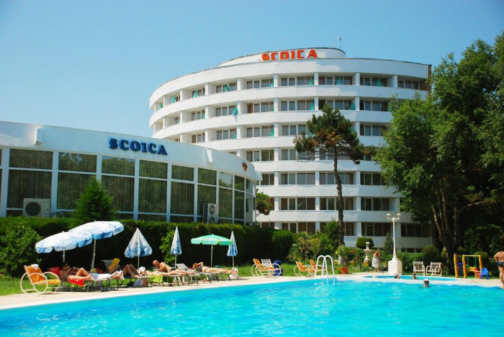 un hotel con piscina frente a un edificio en Hotel Scoica, en Jupiter