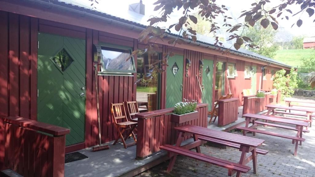 kilka ławek siedzących przed domem w obiekcie Lensmansgarden Fjøsen w mieście Innfjorden