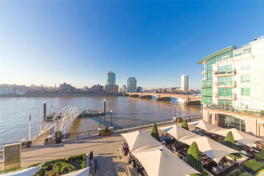 a view of a river with buildings and a bridge at Panoramic Riverside Facing - 2 Bed - 2 Bath - 2 Balconies - in London Nine Elms in London