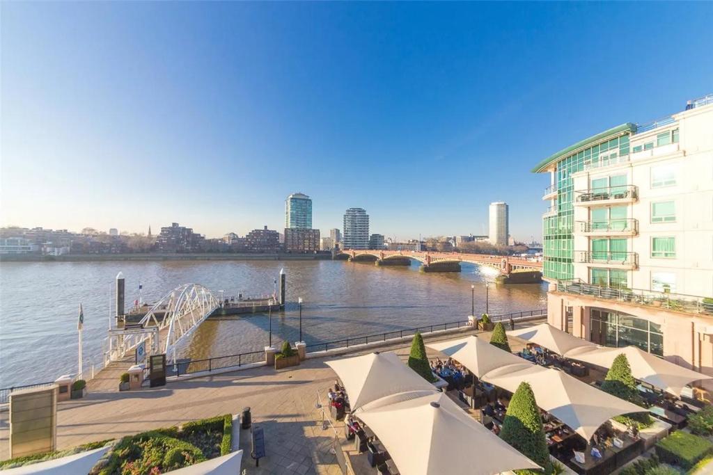 a view of a river with buildings and a bridge at Panoramic Riverside Facing - 2 Bed - 2 Bath - 2 Balconies - London Nine Elms in London