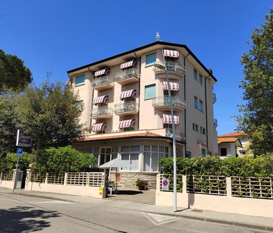 wysoki budynek z balkonami na boku w obiekcie Hotel Puccinelli w mieście Lido di Camaiore