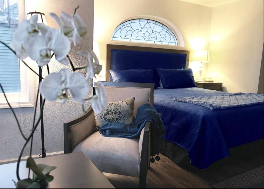 1 dormitorio con 1 cama azul y 1 silla en Hotel Breakers en Gualala