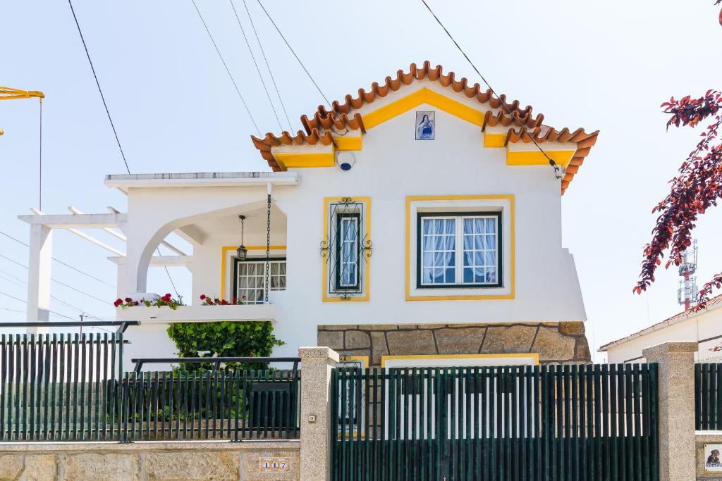 a white house with a black fence at Araújo 111 - Traditional House in Leça do Balio