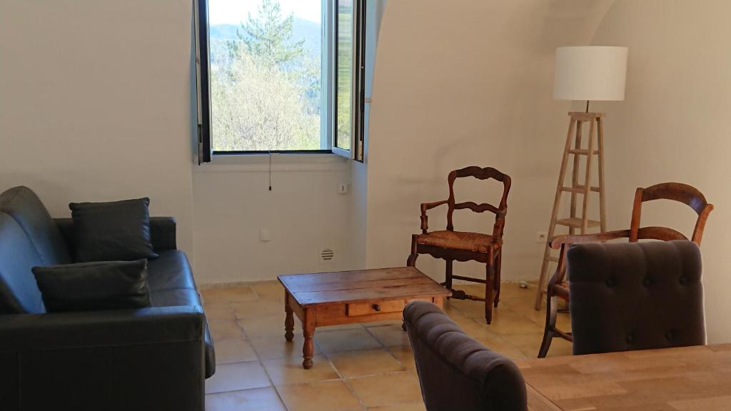 Posezení v ubytování Gîte en Cévennes du sud, bergerie restaurée au rez de jardin d'une bastide avec piscine, vue exceptionnelle, authenticité et confort