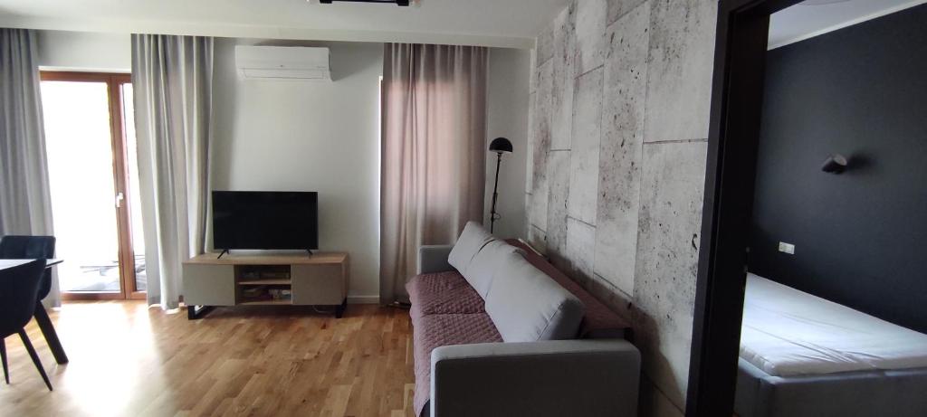 uma sala de estar com um sofá e uma televisão em Apartament rodzinny w obiekcie Nautikka Park em Krynica Morska