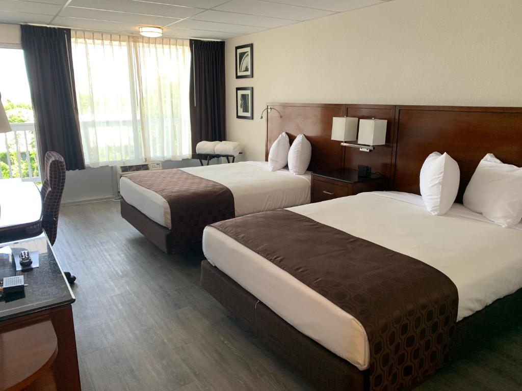 um quarto de hotel com duas camas e uma secretária em The Branson Welcome Inn em Branson