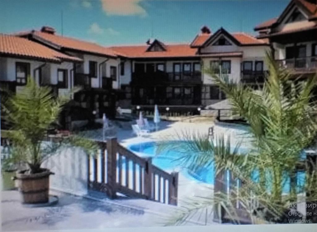 um resort com piscina e palmeiras em Pearl Apartments Sozopol em Sozopol