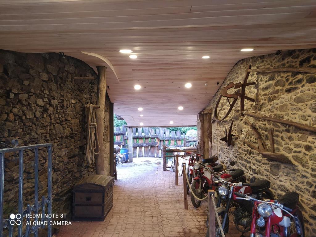 um quarto com uma parede de pedra com motos estacionadas nele em O Viraventos em Betanzos